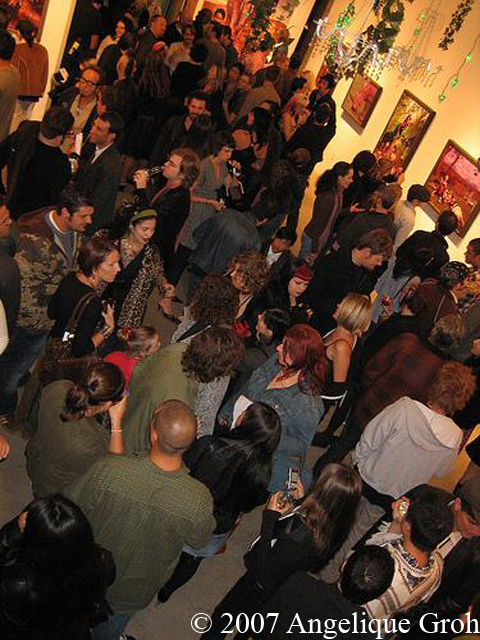 All of the patrons standing in the gallery, looking at paintings.